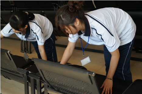 （圖四）志愿者們正在打掃衛(wèi)生，布置文藝節(jié)目現(xiàn)場