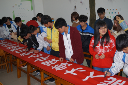 （圖一）學(xué)生們正在學(xué)雷鋒標(biāo)語(yǔ)橫幅上簽名